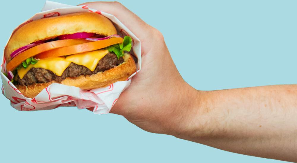 Burger da Jack The Burger com queijo, alface, tomate e cebola roxa
